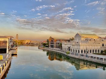 Reflection of buildings in lake at sunset