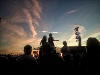 Silhouette people looking at sunset
