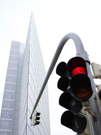 Low angle view of road signal and building in city