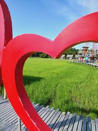 Scenic view of grassy field in city against sky