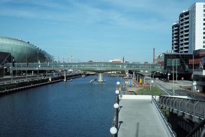 Bridge over river in city against sky