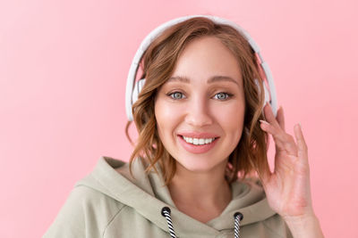 Portrait of a smiling young woman against gray background