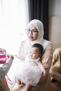 Front view of mother and daughter at home