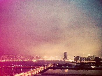 Illuminated cityscape against sky during sunset