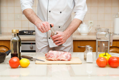 Midsection of man preparing food in kitchen