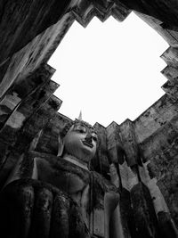 Low angle view of statues on building against sky