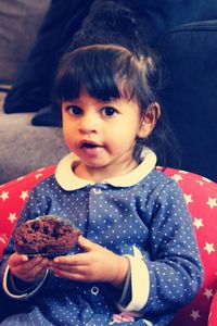 Portrait of innocent girl holding cupcake