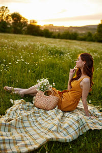 Side view of woman sitting on grass