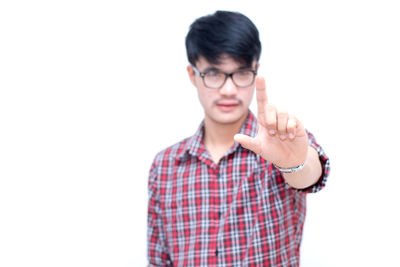 Portrait of young man standing against white background