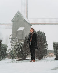 Full length of woman standing on snow covered tree