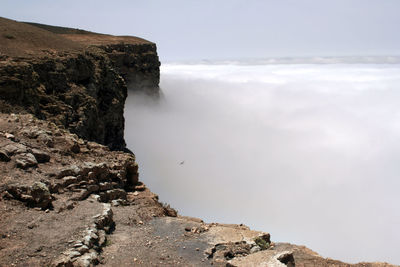 Rocks by sea against sky