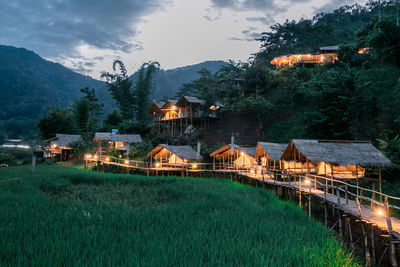 Panoramic shot of illuminated buildings and mountains against sky