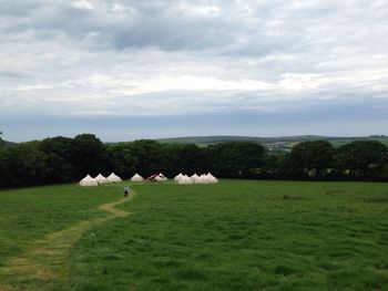 Scenic view of grassy field against cloudy sky