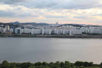 Scenic view of cityscape by mountains against sky