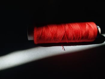 Close-up of red light painting on table against black background