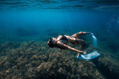 Rear view of woman swimming in sea