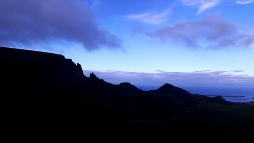 Scenic view of mountains against cloudy sky