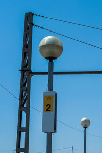 Low angle view of street light against blue sky