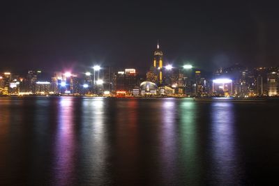 Illuminated central plaza in city by lake at night