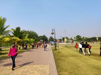 People walking on footpath against sky