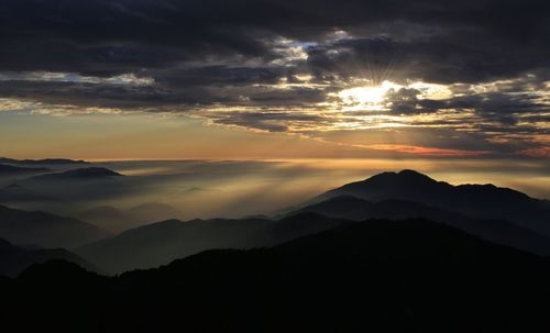 Scenic view of silhouette mountains against sky during sunset