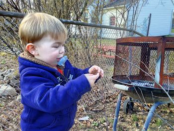 Boy standing by barbecue grill in yard