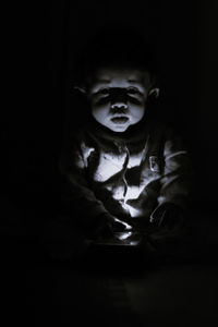 Portrait of cute boy in darkroom