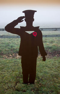 Rear view of silhouette man standing at beach against sky
