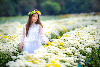 Woman standing on white flowering plants