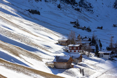 High angle view of snow covered houses by buildings