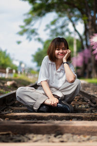 Portrait of a smiling young woman sitting outdoors