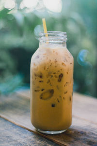 Close-up of iced coffee in glass jar on table
