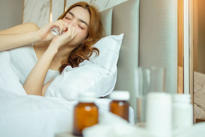 Portrait of young woman lying on bed at home