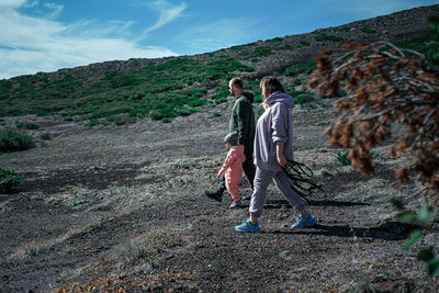 People on mountain against sky