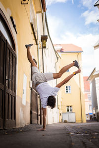 Young man exercising by building