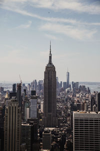 Buildings in city against cloudy sky