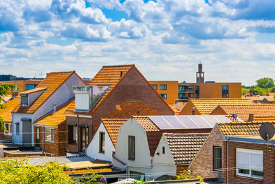 Houses in town against cloudy sky