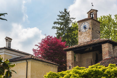 Low angle view of trees and building against sky