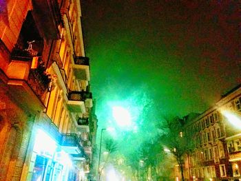 Low angle view of illuminated buildings against sky at night