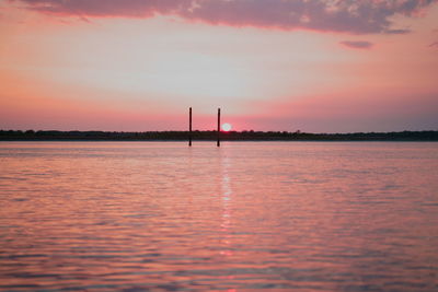 Silhouette sailboat in sea against sky during sunset