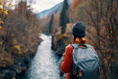 Rear view of woman standing in forest during winter