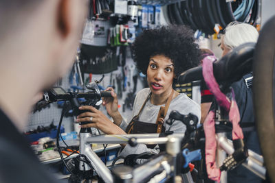 Portrait of friends holding bicycle