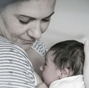 Close-up of happy mother feeding baby girl