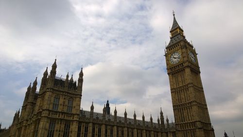 Low angle view of clock tower against buildings in city