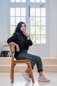 Young woman sitting on sofa at home
