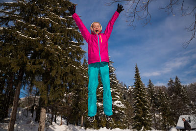 Full length of girl standing on snow covered trees