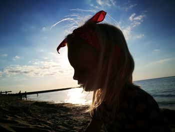 Close-up of girl at beach against sky
