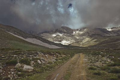 Panoramic view of country road by mountains against sky
