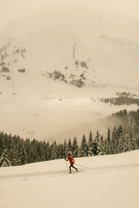 Person skiing on snow against sky