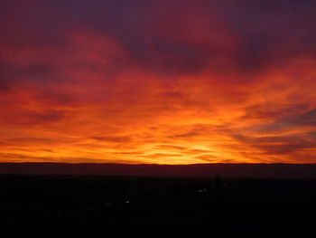 Scenic view of silhouette landscape against orange sky